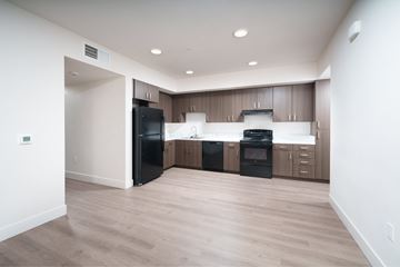 Sacramento apartment for rent - A modern kitchen with wooden cabinets and black appliances.