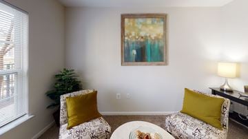 Herndon apartment for rent - A living room with a sofa, a chair, a coffee table, and a painting on the wall.