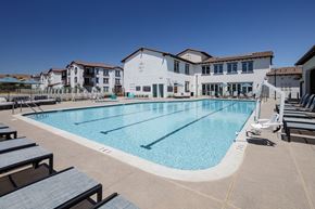 Morgan Hill apartment for rent - a swimming pool with lounge chairs around it in front of a building