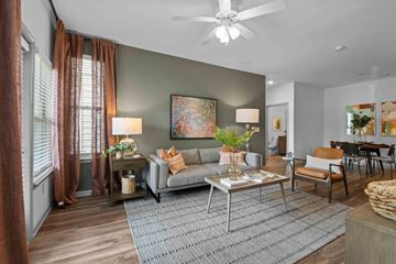 Charlotte apartment for rent - A living room with a grey sofa, a coffee table, and a painting on the wall.