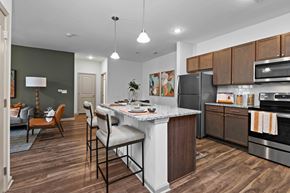 Charlotte apartment for rent - A kitchen with a white island and wooden cabinets.