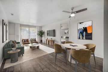 North Salt Lake City apartment for rent - A living room with a green couch, a white coffee table, and a painting on the wall.