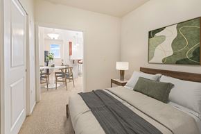 Tacoma apartment for rent - A bedroom with a large bed and a painting on the wall.
