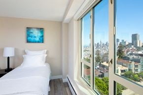 San Francisco apartment for rent - a bedroom with a bed and a large window with a view of the city