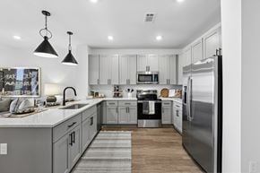 Brentwood apartment for rent - A modern kitchen with a refrigerator, sink, and cabinets.