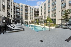 Falls Church townhouse for rent - A pool area with sun loungers and a building in the background.