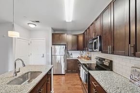 Patchogue apartment for rent - A kitchen with wooden cabinets and granite countertops.