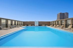 Cleveland apartment for rent - A large swimming pool with lounge chairs and a building in the background.
