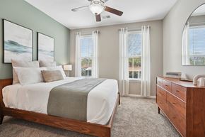 Fort Mill apartment for rent - A bedroom with a bed, dresser, and window with curtains.