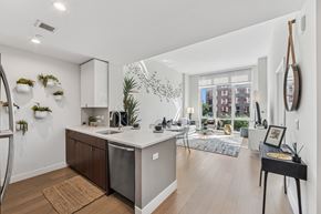 White Plains apartment for rent - A kitchen with a refrigerator, sink, and a dining table with chairs.