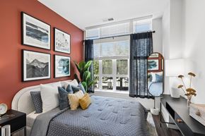 Washington apartment for rent - A bedroom with a bed, nightstand, and a window with blinds.