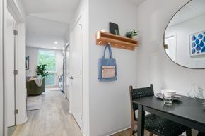 Philadelphia apartment for rent - a dining area with a black dining table and chairs and a round mirror on the wall