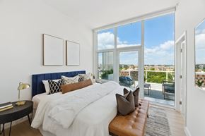 Washington apartment for rent - A bedroom with a large bed and a view of the city.