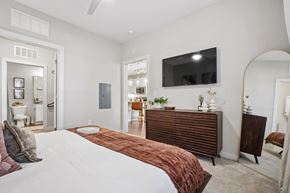 Charlotte apartment for rent - A bedroom with a large bed and a flat screen TV mounted on the wall.