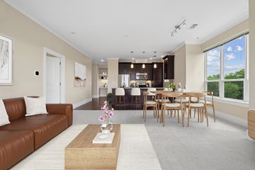 Hudson apartment for rent - A modern living room with a brown leather couch and a wooden coffee table.