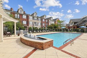 Portsmouth apartment for rent - a swimming pool with a fountain in front of an apartment building