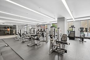 Reston apartment for rent - A gym with various exercise machines and a person working out.