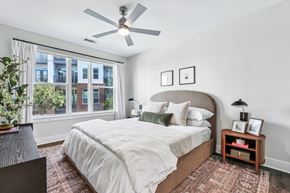 Charlotte apartment for rent - A bedroom with a large bed and a ceiling fan.