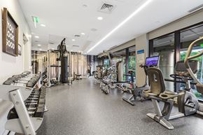 Stamford apartment for rent - a gym with cardio equipment and weights in a building with windows