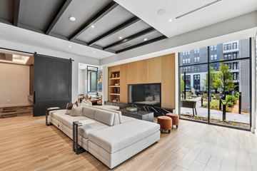 Hyattsville apartment for rent - A modern living room with a grey sofa and a wooden floor.