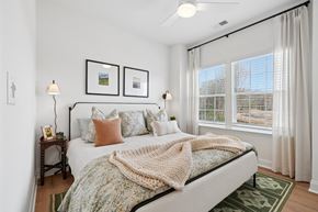 Charlotte townhouse for rent - A bedroom with a bed, two lamps, and pictures on the wall.
