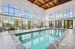 Brooklyn Park apartment for rent - A large indoor swimming pool with a wooden ceiling and a glass wall.