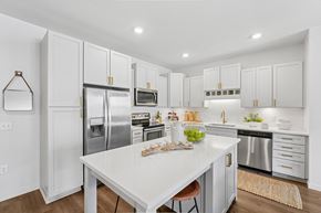 Brooklyn Park apartment for rent - A white kitchen with a table and chairs.
