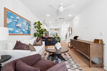 Charlotte townhouse for rent - A living room with a white couch and a painting on the wall.