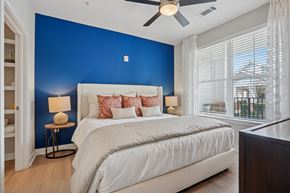 Matthews apartment for rent - A bedroom with a white bed and a ceiling fan.