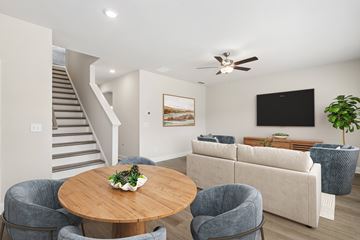 Stone Mountain apartment for rent - A living room with a grey couch, a wooden table and a staircase.