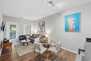 Washington apartment for rent - A modern living room with a glass table and white couch.