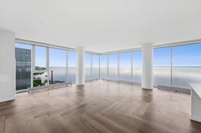 Duluth apartment for rent - A large empty room with wooden floors and large windows overlooking the city.