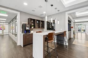 Capitol Heights apartment for rent - A modern kitchen with a white island and brown chairs.