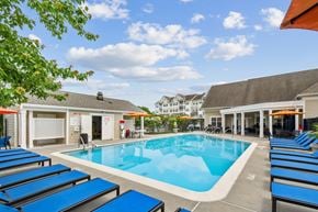 Frederick apartment for rent - A pool surrounded by sun loungers and umbrellas.