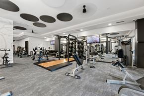 Brooklyn Park apartment for rent - A spacious gym with a variety of equipment and a flat screen TV mounted on the wall.