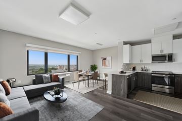 West New York apartment for rent - A modern living room with a grey sofa and a coffee table.