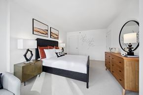 Chicago apartment for rent - A bedroom with a large bed, a chair, and a dresser.