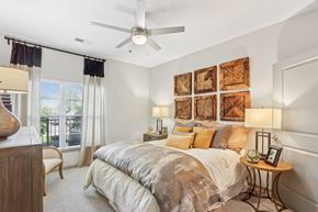 Louisville apartment for rent - A bedroom with a large bed and a ceiling fan.