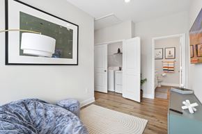 Mcdonough apartment for rent - A bedroom with a bed covered in a blue blanket and a white lamp on the wall.