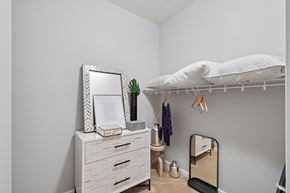 Washington apartment for rent - A white dresser with a mirror and a white bed with a white pillow.