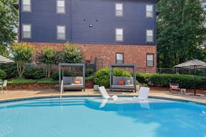 Decatur apartment for rent - A blue swimming pool in front of a brick building.