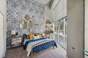 Pittsburgh apartment for rent - A bedroom with a bed, nightstand, and a wall covered in blue and white tiles.