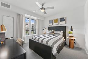 Brooklyn Park apartment for rent - A bedroom with a large bed and a ceiling fan.