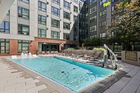 Washington apartment for rent - A swimming pool surrounded by a brick wall and lounge chairs.