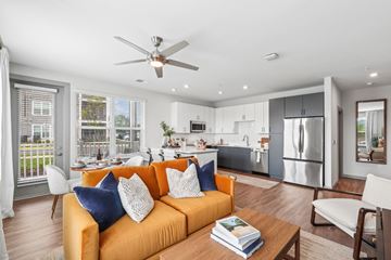 Fredericksburg apartment for rent - A modern living room with a yellow sofa and a ceiling fan.