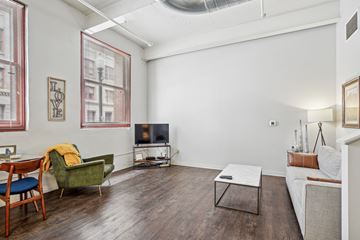Pittsburgh apartment for rent - A living room with a green chair and a white couch.