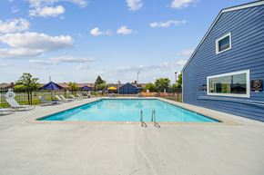 Indianapolis apartment for rent - A swimming pool with a blue sky and clouds in the background.