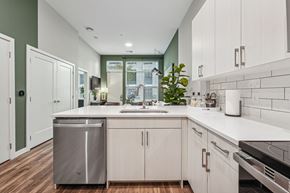 Baltimore apartment for rent - an open kitchen with white cabinets and a sink and a window