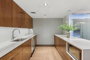 New York apartment for rent - A modern kitchen with wooden cabinets and a white countertop.