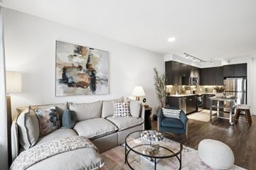 Rockville apartment for rent - A modern living room with a grey sofa and a large abstract painting on the wall.